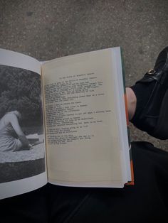 an open book with black and white photograph of a woman kneeling down on the ground