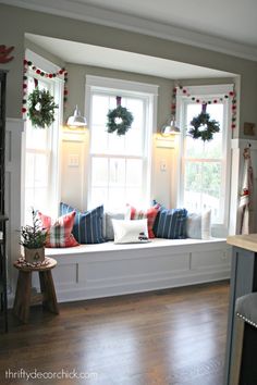 a window seat with wreaths on the windowsill