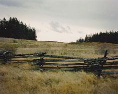 an old wooden fence in the middle of a field