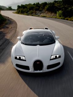 a white bugatti is driving down the road