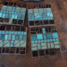 four pieces of stained glass sitting on top of a table