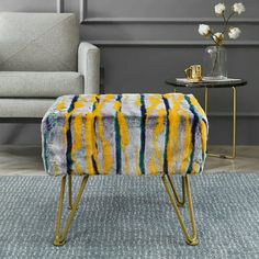 a yellow and blue bench sitting on top of a rug