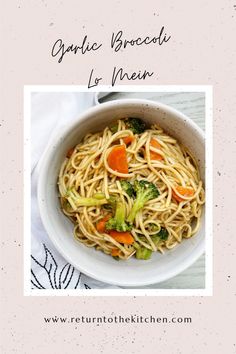 a white bowl filled with noodles and veggies on top of a table cloth