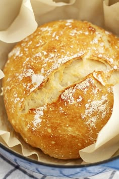 a loaf of bread with powdered sugar on top sits in a blue and white bowl