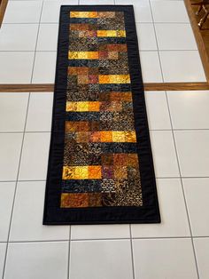 a black and yellow patchwork rug on the floor in front of a stair case