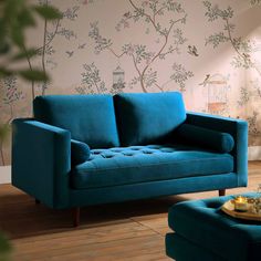 a blue couch sitting on top of a hard wood floor next to a coffee table