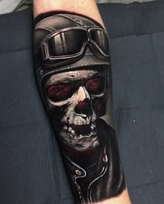 a man's arm with a skull and motorcycle helmet on it