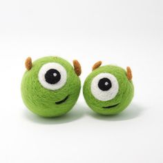 two green balls with googly eyes on white background