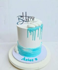 a white and blue birthday cake with drips on it