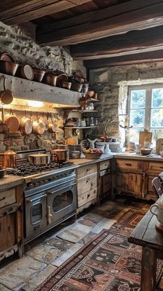 an old fashioned kitchen with many pots and pans on the stove top, along with a rug