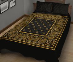 a black and gold bedspread on a bed in a room with wood floors