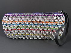 a multicolored handbag is sitting on a black surface and has a strap around it