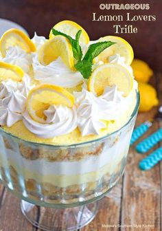 lemon lovers trifle in a glass dish with whipped cream and sliced lemons