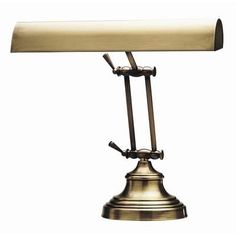 an antique brass desk lamp with a white shade on the top and one light turned off