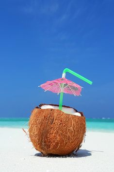 a coconut drink with an umbrella on the beach