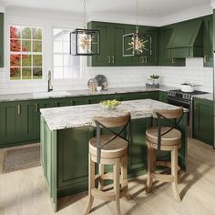 a kitchen with green cabinets and marble counter tops, two stools at the island