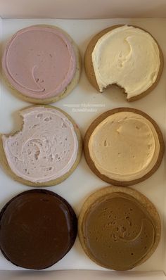 six cookies with different colored frosting in a box