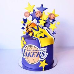 a birthday cake decorated with the los angeles lakers logo and basketballs, stars and balls