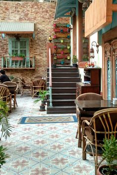 the inside of a restaurant with tables, chairs and potted plants on the floor