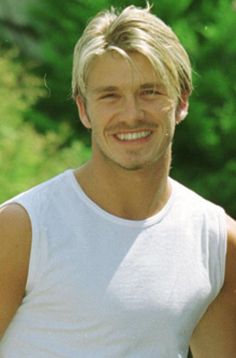 a man with blonde hair smiling at the camera