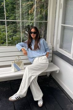 Adidas Samba sneakers are the hottest style right now, and if you're looking for styling inspiration for casual spring outfits, you're in the right place. For example, we just love this white wide leg outfit with a pale blue sweater – so chic!