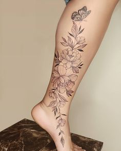 a woman's leg with flowers and butterflies on it