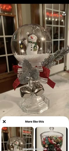 a snowman in a glass bowl on top of a table with silver and red ribbon