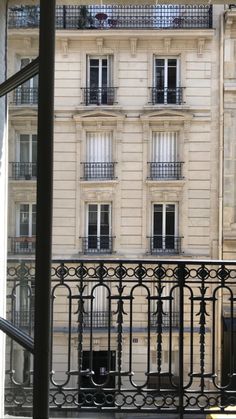 an apartment building with balconies is seen through a window