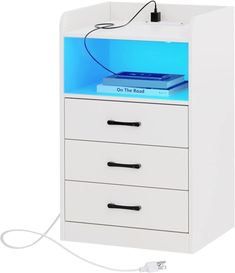 a white cabinet with three drawers and a blue light on top that is plugged in