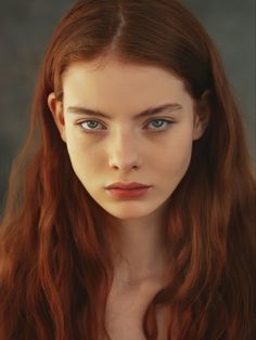 a woman with long red hair and blue eyes