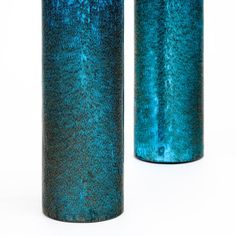 two blue vases sitting side by side on a white surface