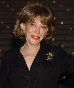 an older woman with brown hair and red lipstick