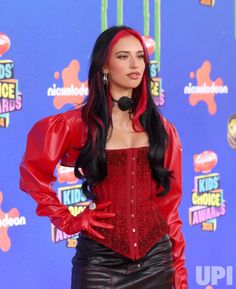 a woman with long black hair wearing a red corset and leather skirt at the kids'choice awards