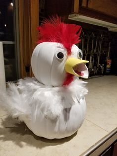 a white and red chicken sitting on top of a counter