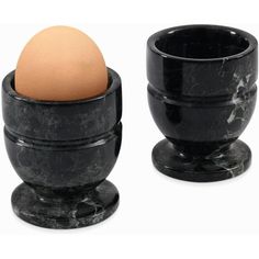 two black marble egg cups with an egg in them