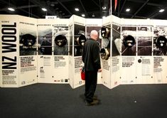 a man standing in front of a wall with posters on it