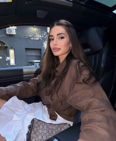 a woman sitting in the driver's seat of a car