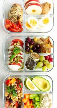 four plastic containers filled with different types of food in each container, one containing an egg, the other containing vegetables and fruit