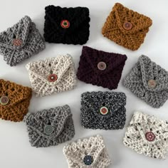 nine crocheted wrist warmers are arranged on a white surface, with buttons in the middle