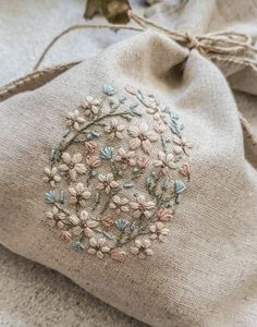 a small bag with embroidered flowers on it