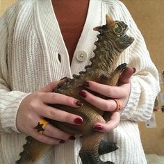 a woman holding a lizard in her hands