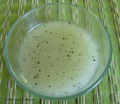 a glass bowl filled with liquid sitting on top of a green tablecloth covered place mat