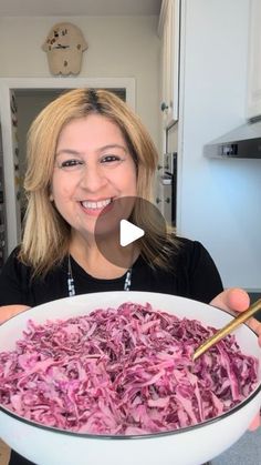 a woman holding a bowl full of red cabbage