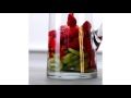 a glass filled with water and fruit on top of a table