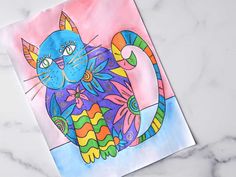 a drawing of a colorful cat on a piece of paper