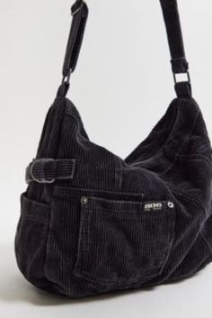 Slouchy crossbody sling bag by BDG, crafted from durable cord with a single adjustable strap. Features a main compartment with zip-up fastening and tech pockets stitched to the outside. Only at UO. **Content + Care** \- 100% Cotton \- Wipe clean **Size** \- D: 12cm x W: 35cm x H: 27cm | BDG Corduroy Sling Bag - Black at Urban Outfitters Corduroy Crossbody Bag, Trendy Bags Street Style, Crossbags Women, Travel Bags Aesthetic, Grunge Messenger Bag, 90s Bags, Crossbody Bookbag, Grunge Bag, Baggy Bag