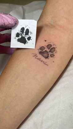 a person with a dog paw tattoo on their arm