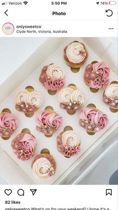 cupcakes with white frosting and pink icing on top in a box