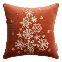 a red pillow with white snowflakes on it