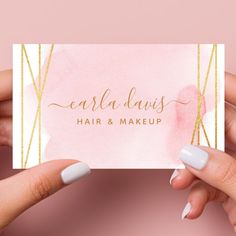 two hands holding up a pink business card with gold foil lettering on the front and bottom